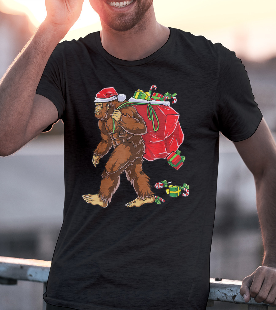 Bigfoot Santa With Giant Red Christmas Bag And Green Gifts Wearing Xmas Hat T-Shirt