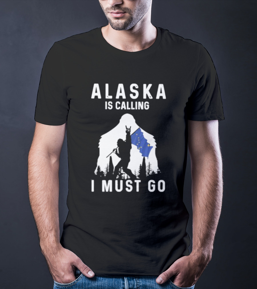 Alaska Is Calling I Must Go Bigfoot Holding Alaska Flag T-Shirt