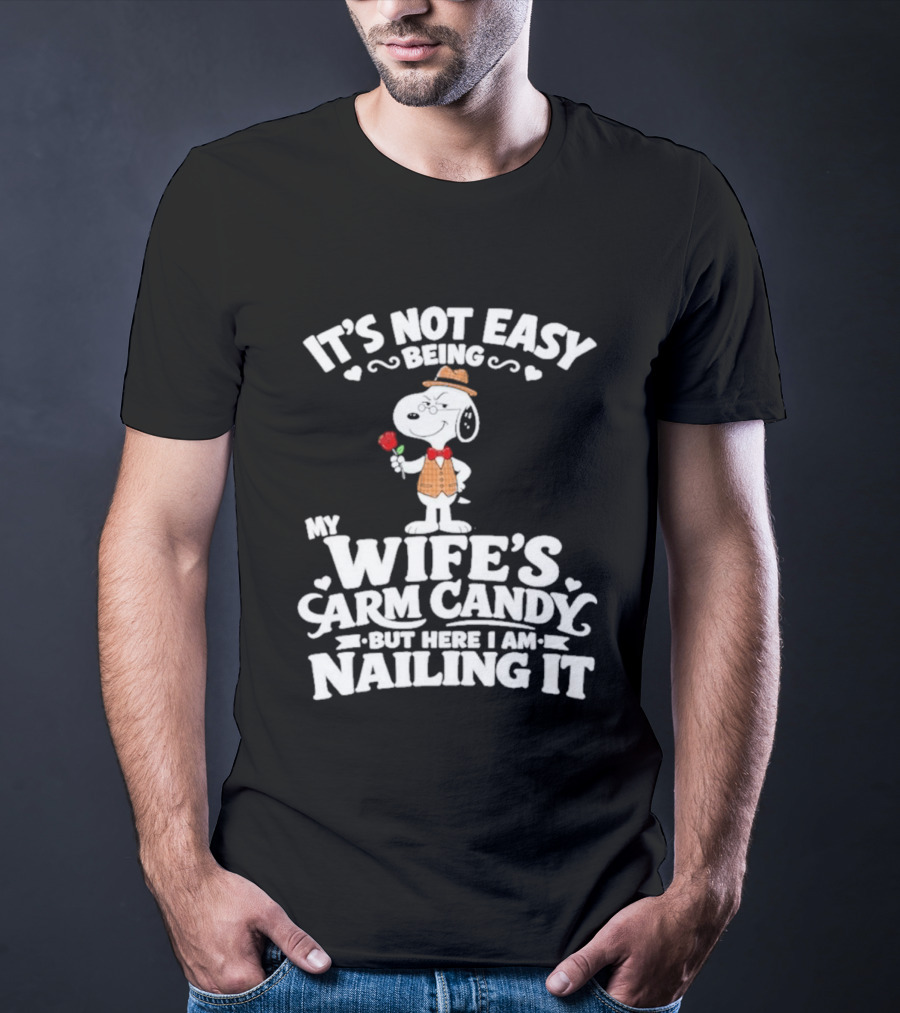 Snoopy It's Not Easy Being My Wife's Arm Candy But Here I Am Nailing It T-Shirt