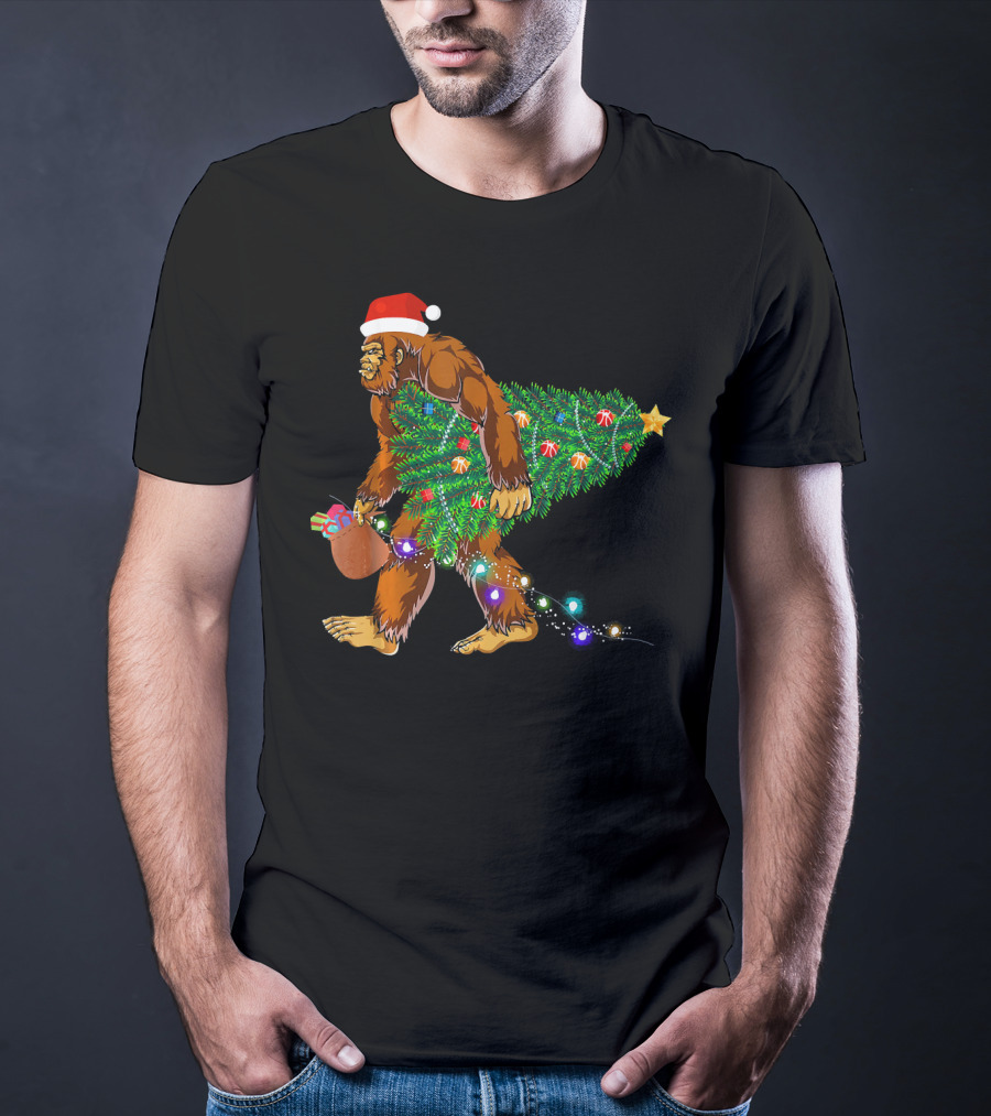 Santa Hat Bigfoot Holding Christmas Tree With Lights And Gifts T-Shirt